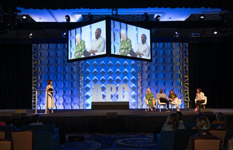 Rachel Kopczyk (emcee) introducing Lucy Brazier, Tony Crawford, Sunny Nunan, and Lynn Walder on stage at APC 2023